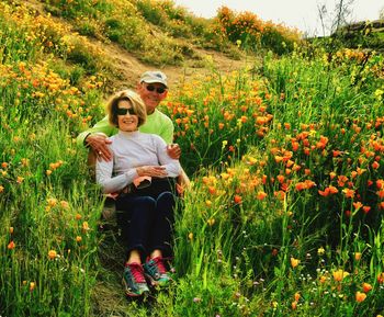 Full length of friends on flower field