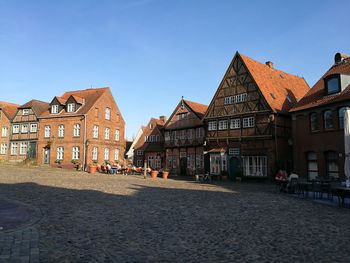 Houses by street in town against sky