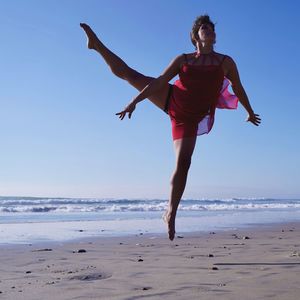 Full length of woman on beach against clear sky