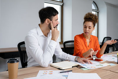 Colleagues working at desk in office