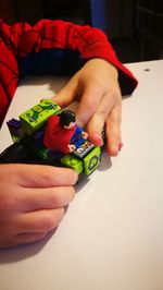 Close-up of hand holding multi colored christmas decorations