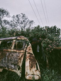 Low angle view of abandoned vehicle against sky