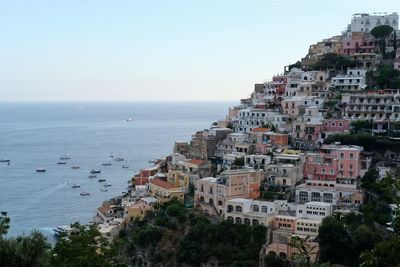 Scenic view of sea by buildings against sky