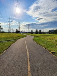 Road amidst field against sky