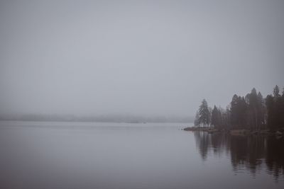 Scenic view of lake against sky in foggy weather