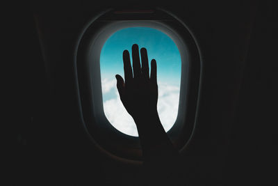 Silhouette person seen through airplane window