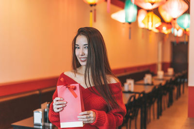 Portrait of young woman holding drink