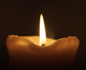 Close-up of burning candle in darkroom