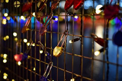 Close-up of illuminated lights hanging on fence