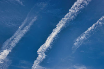 Low angle view of vapor trail against blue sky