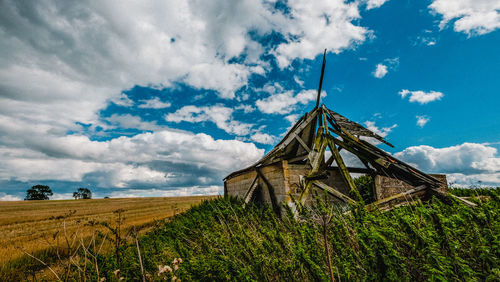 Scenic view of grassy field against cloudy sky