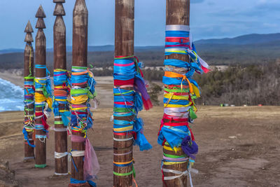 Close-up of multi colored umbrellas on field against sky