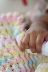 Close-up of baby hand on bed