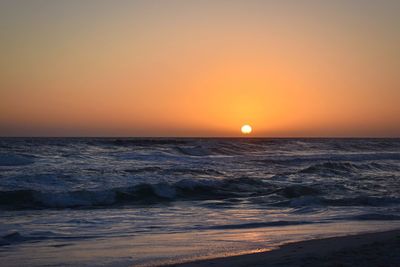 Scenic view of sea against orange sky