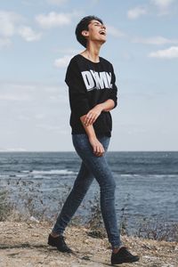 Full length of man standing on beach against sky