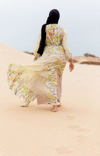 Rear view of woman walking on beach