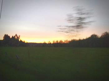 Scenic view of silhouette field against sky during sunset