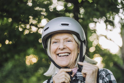 Happy senior woman looking away wearing sports helmet