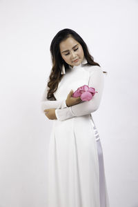 Portrait of a smiling young woman against white background