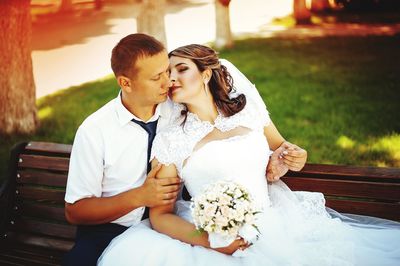 Couple sitting on bench during wedding