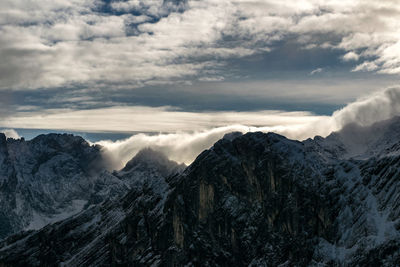 Scenic view of mountains against cloudy sky