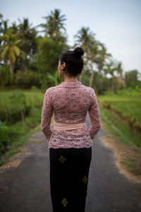 Rear view of woman walking on footpath