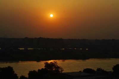 Scenic view of lake against orange sky