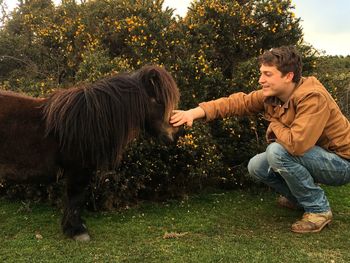 Full length of boy with horse on tree