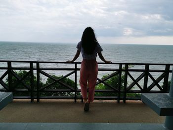 Rear view of woman looking at sea against sky