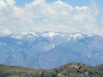 Scenic view of mountains against cloudy sky