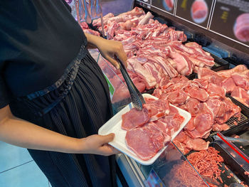 Midsection of person preparing food at market stall