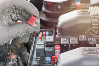 Cropped image of hands holding tool on vehicle