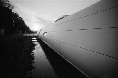 Tilt image of railroad tracks in city against sky