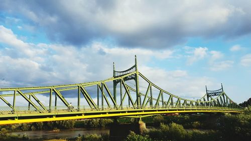 Low angle view of suspension bridge against sky