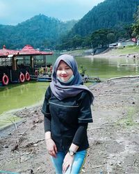 Portrait of smiling young woman standing on land