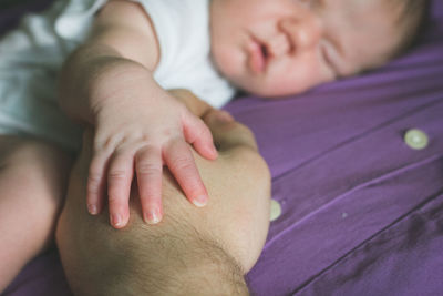 Close-up of cute baby girl sleeping on father chest