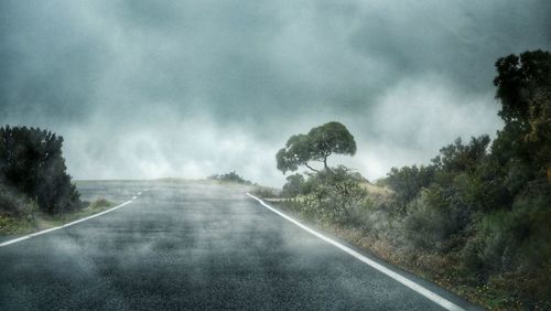 Empty road against cloudy sky