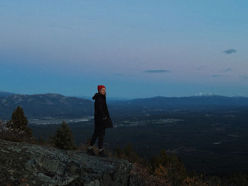 Rear view of woman standing on mountain