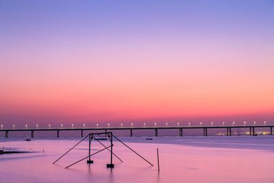Scenic view of snow covered field against orange sky