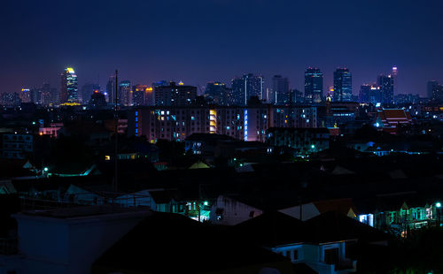 Illuminated cityscape against sky at night