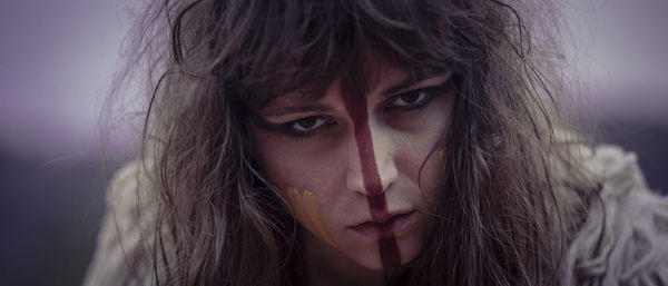 Close-up portrait of serious spooky woman with face paint