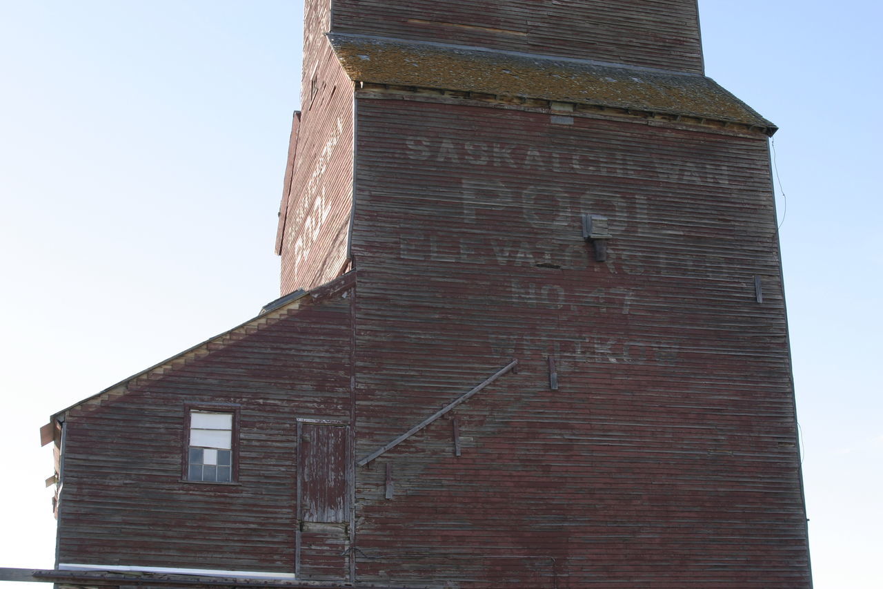 building exterior, architecture, built structure, low angle view, clear sky, brick wall, tower, building, tall - high, copy space, outdoors, day, no people, exterior, sky, wall - building feature, sunlight, city, window, high section