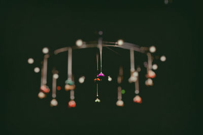 Close-up of wind chime hanging in darkroom