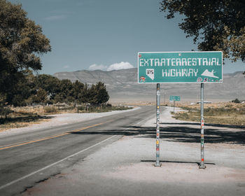 Road sign against sky