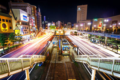 High angle view of light trails on road along buildings