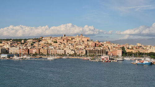 Buildings by sea against sky in city