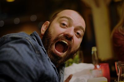 Portrait of man with open mouth at home