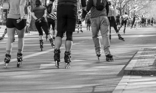 People skateboarding on road in city