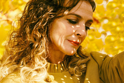 Close-up of mature woman against autumn leaves