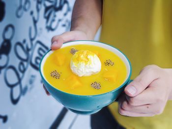 Midsection of person holding yellow bowl